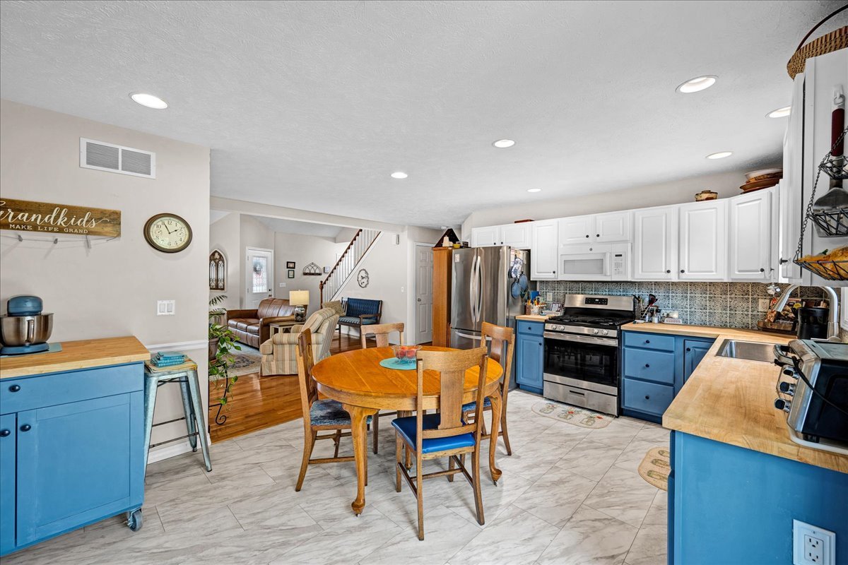 204 Field Drive Normal, IL 61761 - Photo 9 of 34 a kitchen with stainless steel appliances kitchen island granite countertop a table chairs sink and cabinets