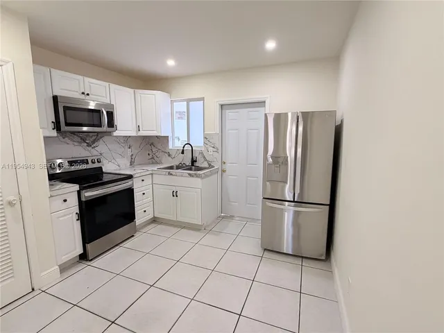 a kitchen with stainless steel appliances a refrigerator sink and microwave