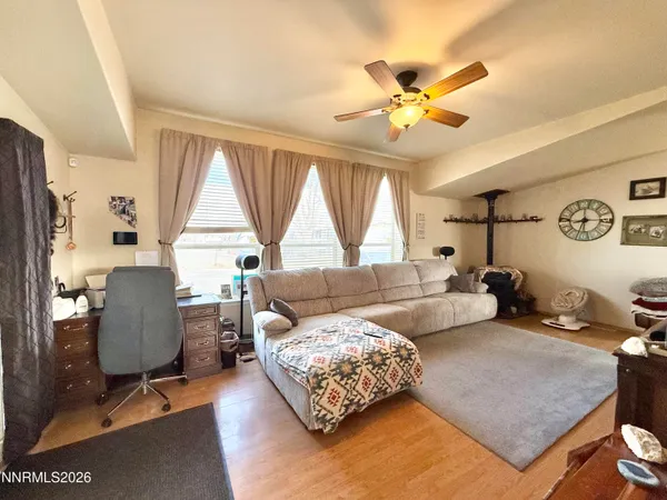 a living room with furniture and a large mirror with wooden floor