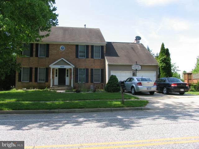 a front view of a house with a garden and plants