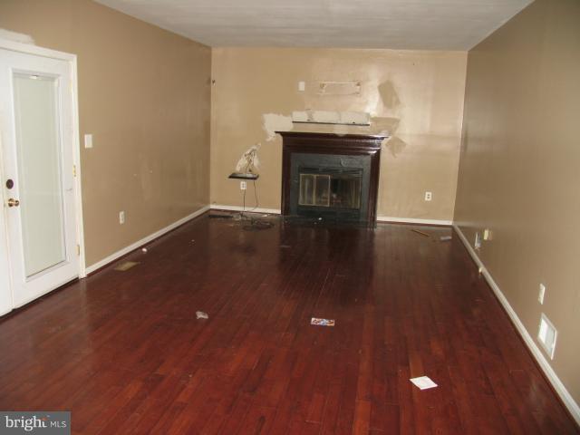 1600 Golf Course Drive Bowie, MD 20721 - Photo 17 of 21 a view of empty room with wooden floor and fireplace