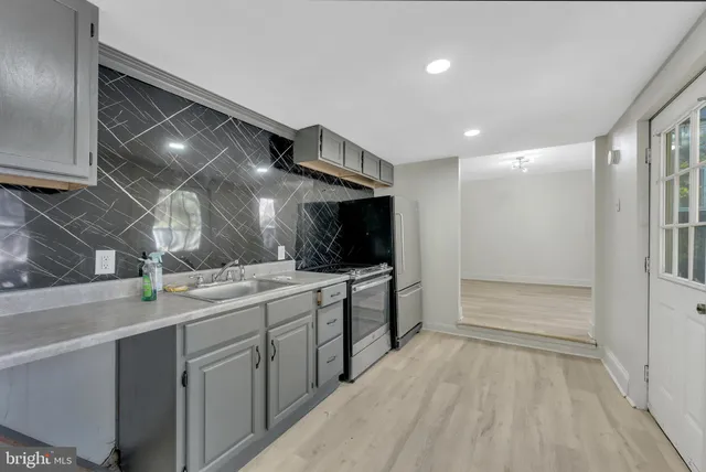 a large white kitchen with a sink and dishwasher