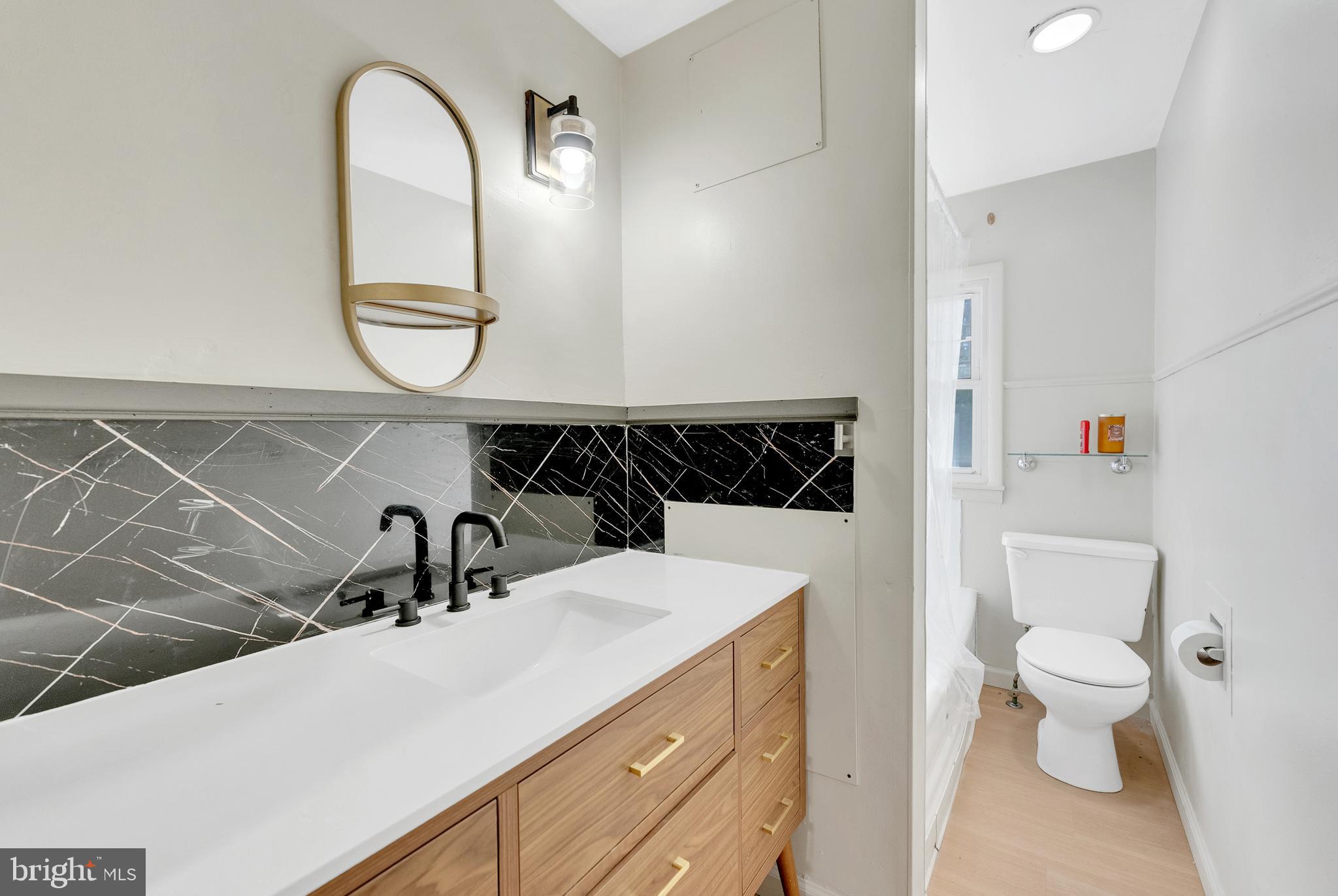 8 Church Street, Unit B Mount Holly, NJ 08060 - Photo 10 of 15 a bathroom with a sink a toilet and a mirror