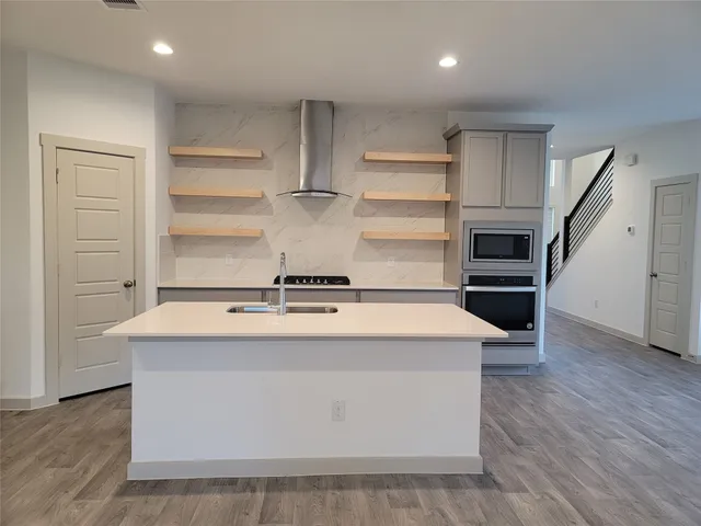 a view of kitchen with wooden floor and electronic appliances