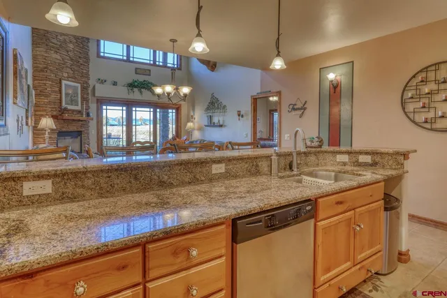 a kitchen with stainless steel appliances granite countertop a sink a stove and a wooden cabinets