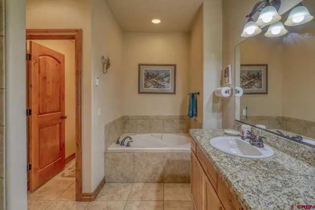 a bathroom with a granite countertop sink mirror and bathtub