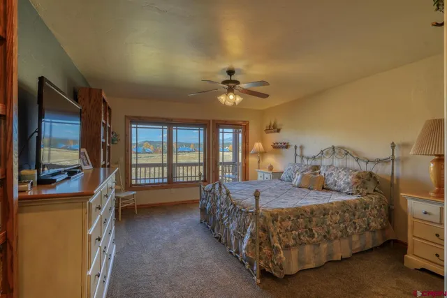 a bedroom with a bed chandelier and a window