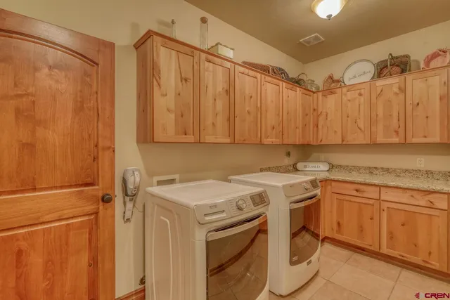 a utility room with a sink a cabinetry and a window