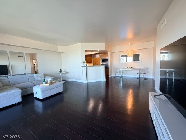 2777 Paradise Road, Unit 807 Las Vegas, NV 89109 - Photo 40 of 61 Rich hardwood flooring stretches across an open-concept living and dining area, leading to a contemporary kitchen.