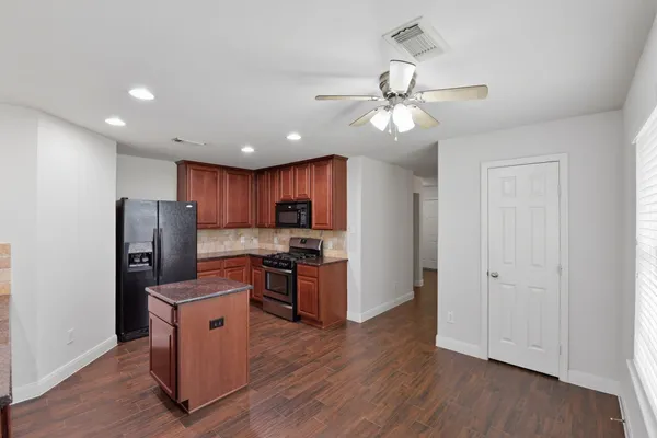 a kitchen with stainless steel appliances granite countertop a refrigerator a stove a sink and a refrigerator