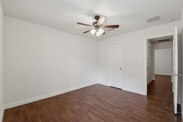 a view of empty room with wooden floor