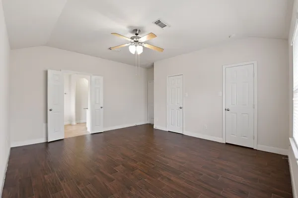 a view of an empty room with wooden floor