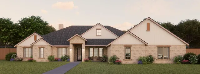 a view of a house with brick walls and a yard with plants