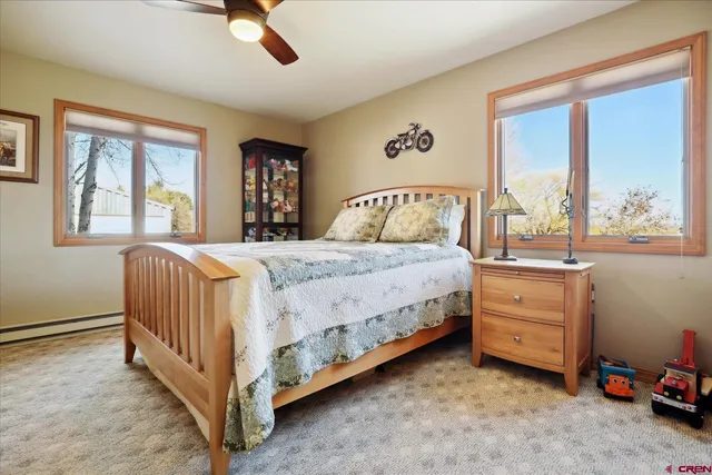 a bedroom with a bed and a dresser next to a window