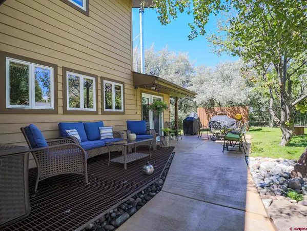 a view of a patio with table and chairs with wooden fence