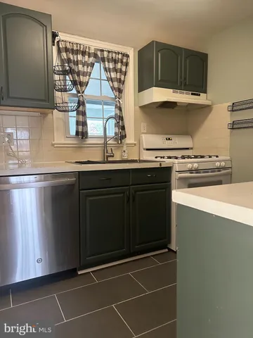 a kitchen with stainless steel appliances a sink stove and cabinets