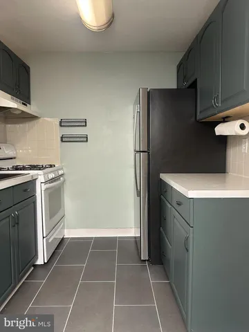 a kitchen with a refrigerator and a stove top oven