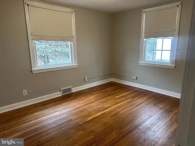 a view of a room with wooden floor and windows