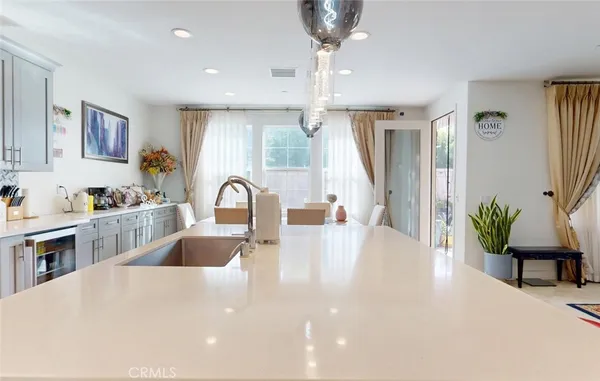 a large white kitchen with sink a refrigerator and a fireplace