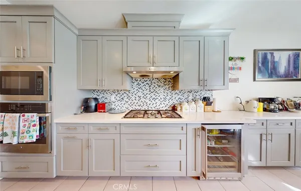 a kitchen with white cabinets and appliances