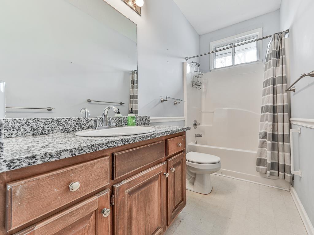 1450 Athens Avenue Southwest Atlanta, GA 30310 - Photo 18 of 35 a bathroom with a granite countertop sink toilet mirror and shower