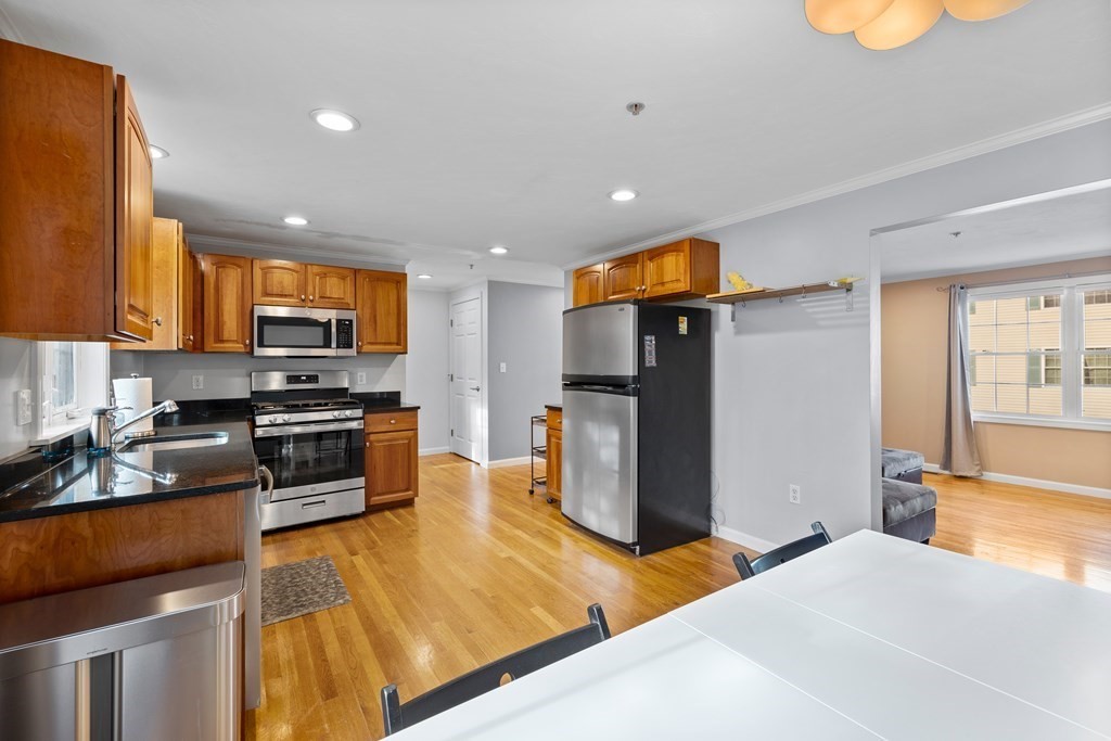 995 Trapelo Road, Unit 5 Waltham, MA 02452 - Photo 11 of 32 a kitchen with stainless steel appliances granite countertop a refrigerator and a stove top oven