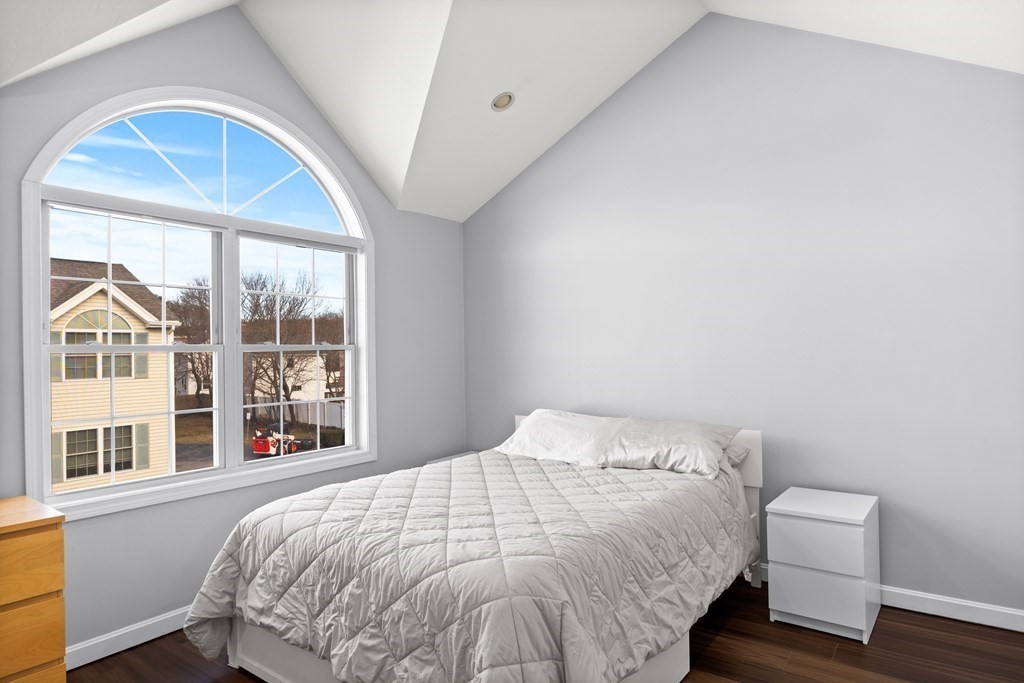 995 Trapelo Road, Unit 5 Waltham, MA 02452 - Photo 17 of 32 a bedroom with a bed and a large window
