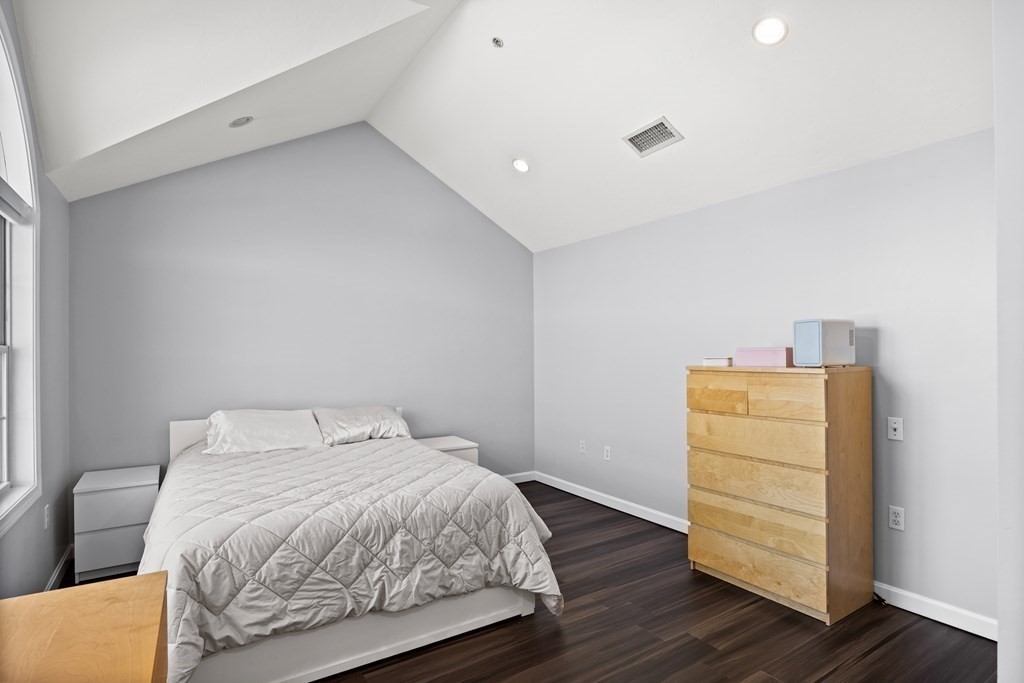 995 Trapelo Road, Unit 5 Waltham, MA 02452 - Photo 18 of 32 a bedroom with a bed and wooden floor