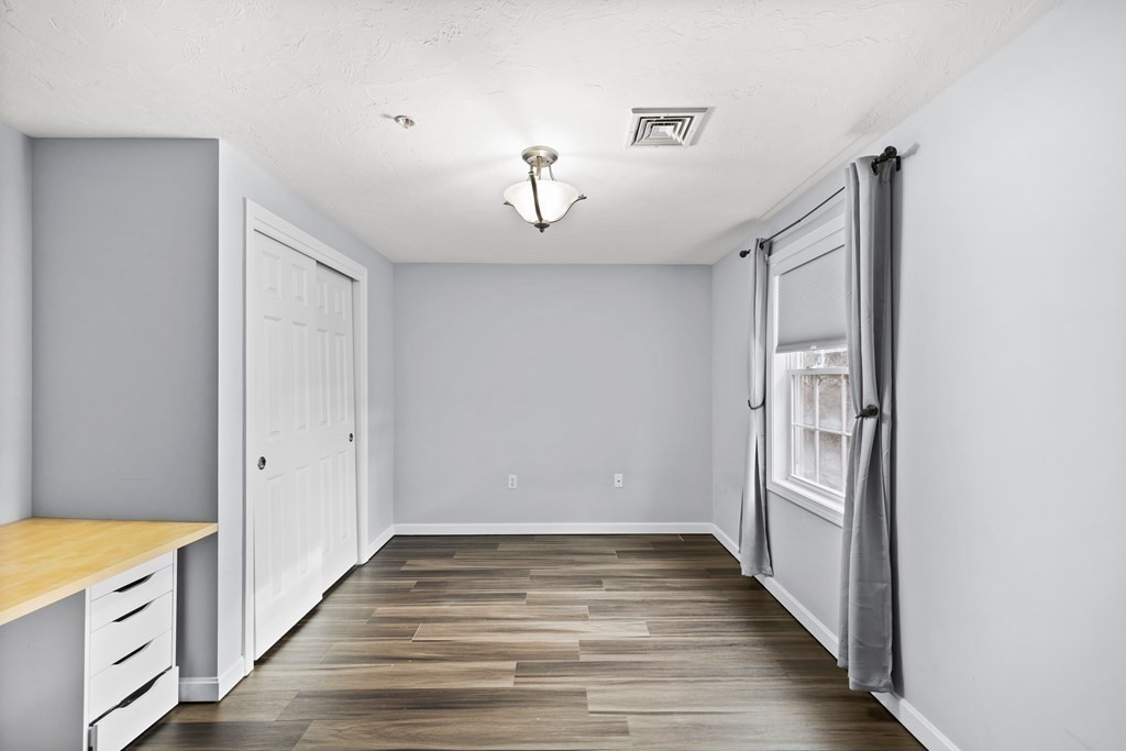 995 Trapelo Road, Unit 5 Waltham, MA 02452 - Photo 19 of 32 a view of an empty room with wooden floor and a window