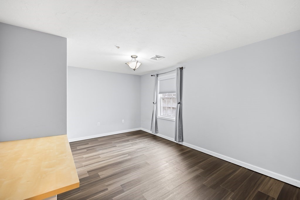 995 Trapelo Road, Unit 5 Waltham, MA 02452 - Photo 20 of 32 a view of an empty room with wooden floor