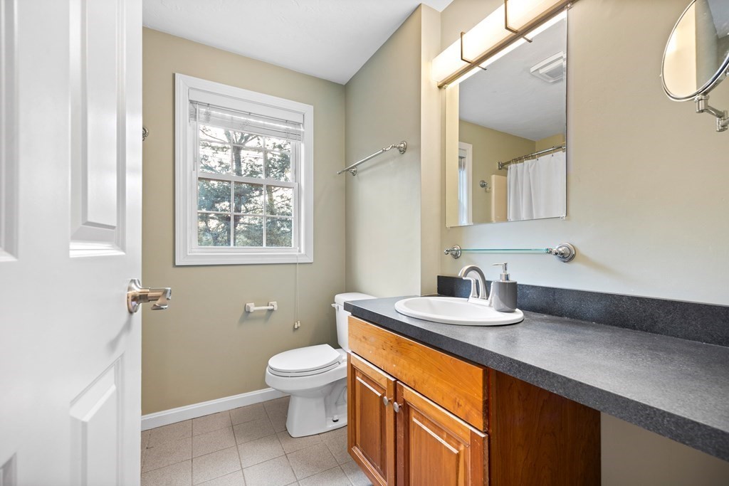 995 Trapelo Road, Unit 5 Waltham, MA 02452 - Photo 22 of 32 a bathroom with a granite countertop sink mirror vanity and toilet