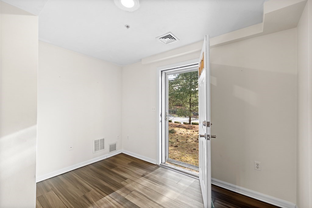 995 Trapelo Road, Unit 5 Waltham, MA 02452 - Photo 26 of 32 a view of an empty room with wooden floor and a window