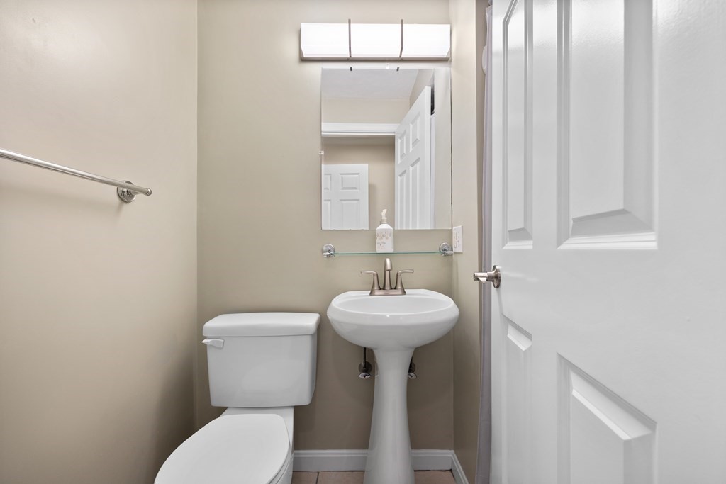 995 Trapelo Road, Unit 5 Waltham, MA 02452 - Photo 27 of 32 a bathroom with a toilet sink and mirror