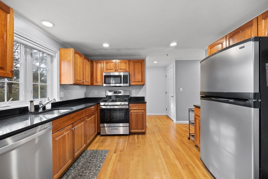995 Trapelo Road, Unit 5 Waltham, MA 02452 - Photo 8 of 32 a kitchen with stainless steel appliances a stove sink and microwave