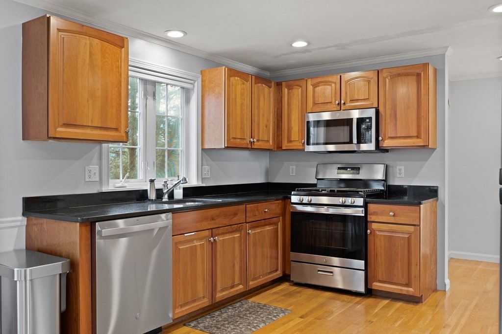 995 Trapelo Road, Unit 5 Waltham, MA 02452 - Photo 9 of 32 a kitchen with stainless steel appliances granite countertop a stove a sink and a microwave