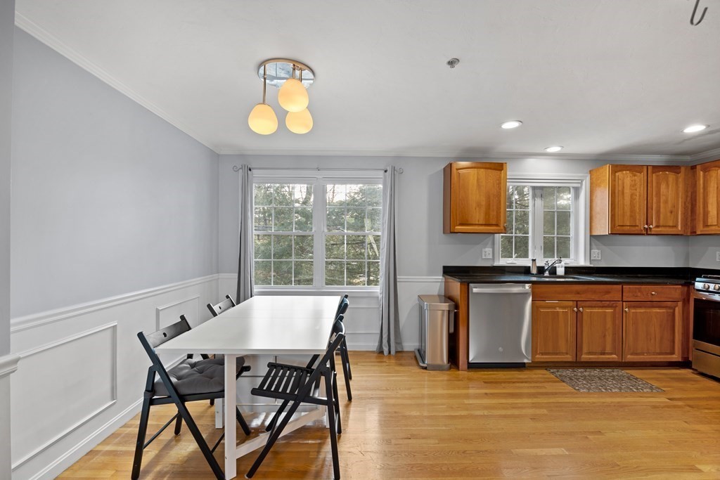 995 Trapelo Road, Unit 5 Waltham, MA 02452 - Photo 10 of 32 a kitchen with stainless steel appliances granite countertop a stove top oven a sink dishwasher a dining table and chairs with wooden floor