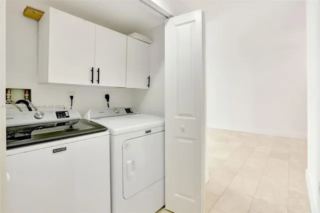 a kitchen with stainless steel appliances a stove a sink and white cabinets