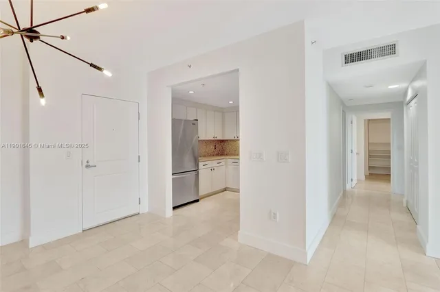 a view of a hallway with a kitchen space and a sink