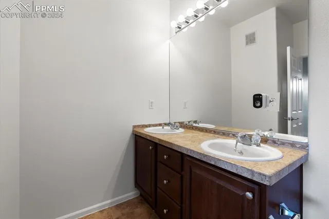 a bathroom with a granite countertop bathtub shower sink vanity and toilet