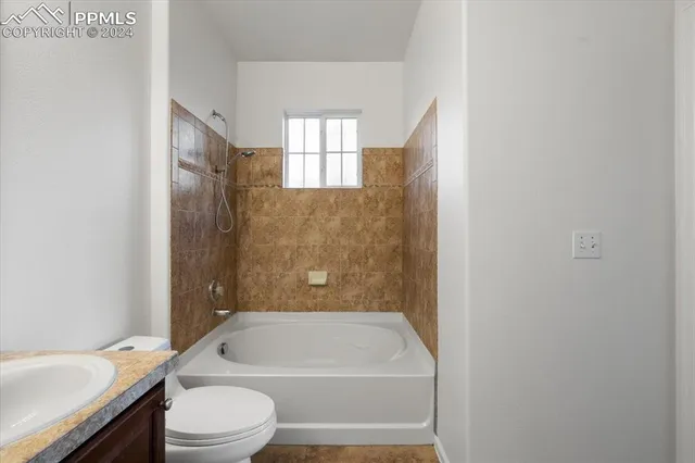 a bathroom with a toilet sink and a mirror