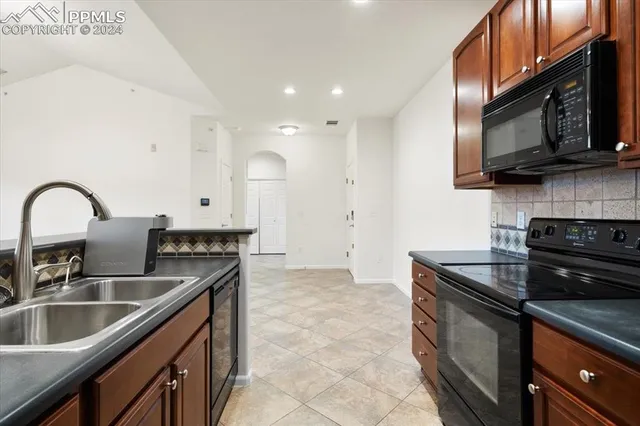 a kitchen with stainless steel appliances granite countertop a stove a sink and a refrigerator