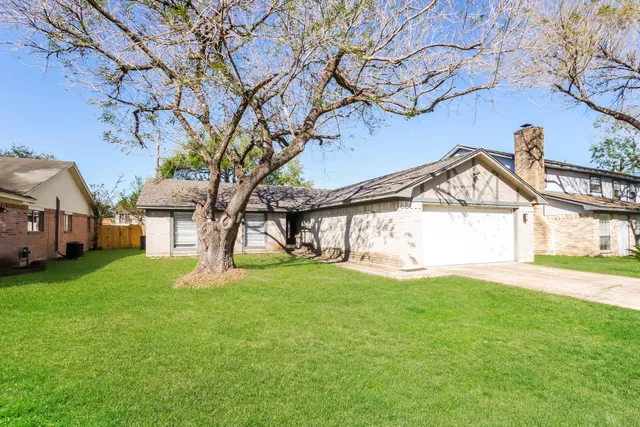 a view of a house with a yard and a tree