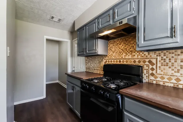 a kitchen with granite countertop a stove and a sink