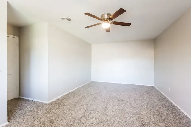 an empty room with closet and fan