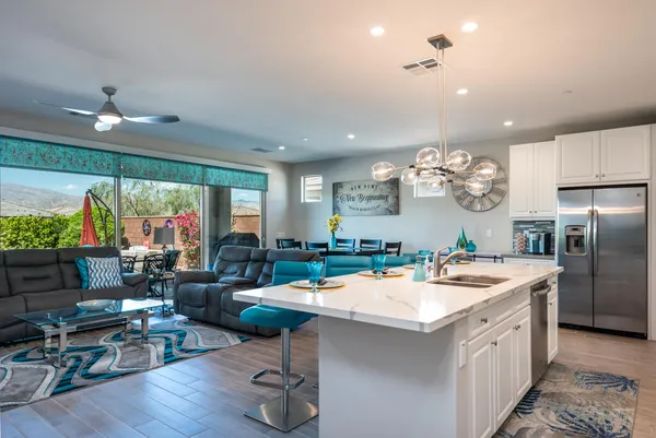 a kitchen with a sink appliances and living room view