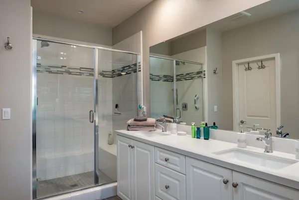 a bathroom with a shower sink vanity granite and mirror
