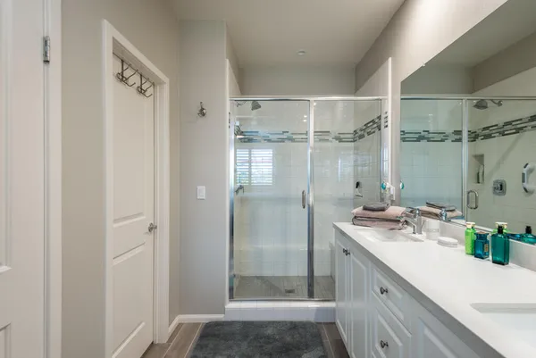 a bathroom with a shower sink vanity and mirror