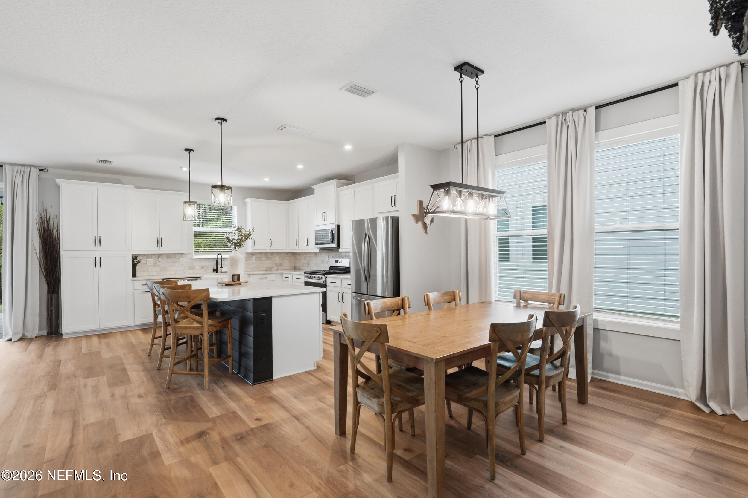 49 Oak Shadow Place St. Johns, FL 32259 - Photo 18 of 48 a dining area with a table chairs wooden floor and kitchen view