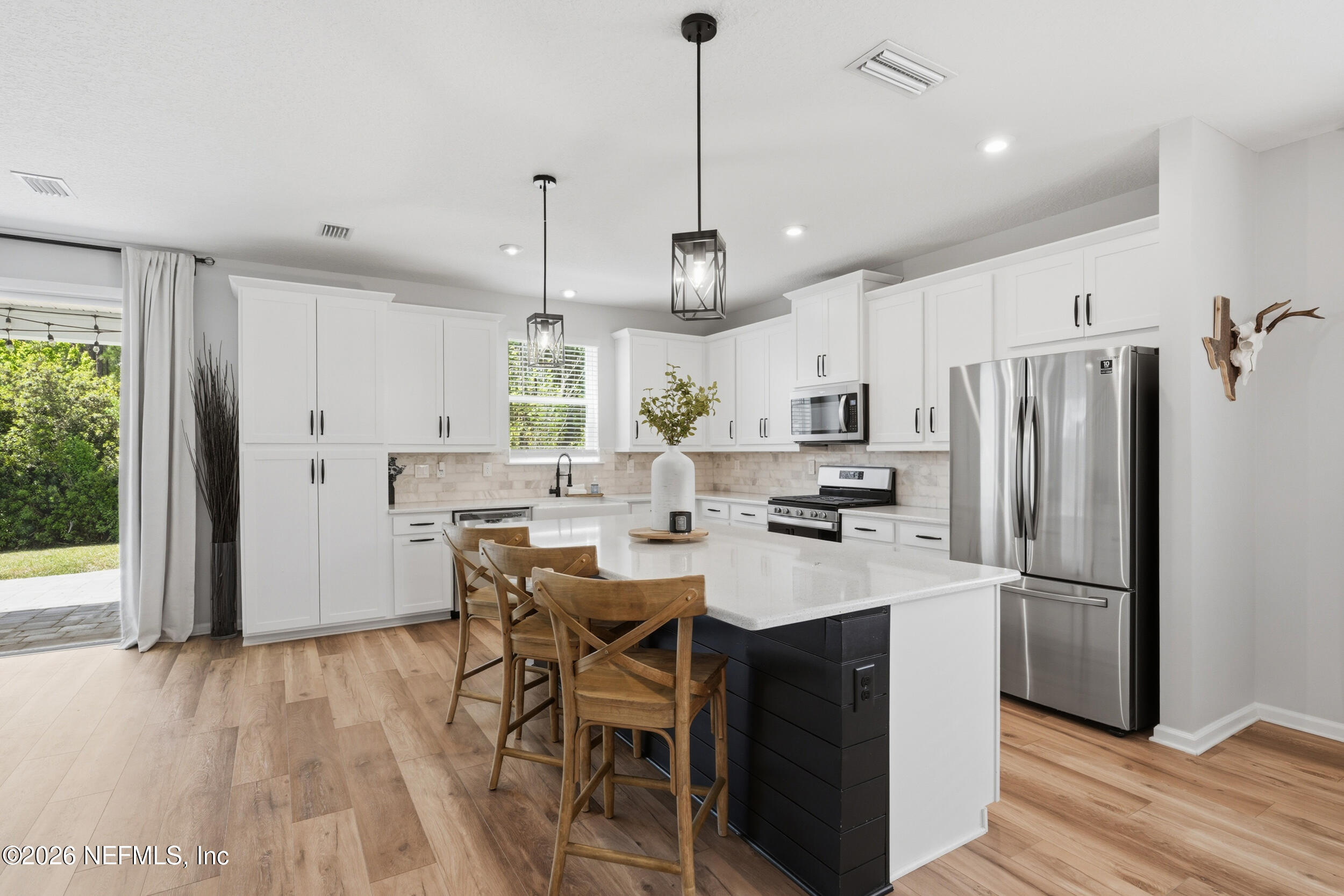 49 Oak Shadow Place St. Johns, FL 32259 - Photo 5 of 48 a kitchen with stainless steel appliances granite countertop a refrigerator a sink dishwasher a stove and white countertops with wooden floor