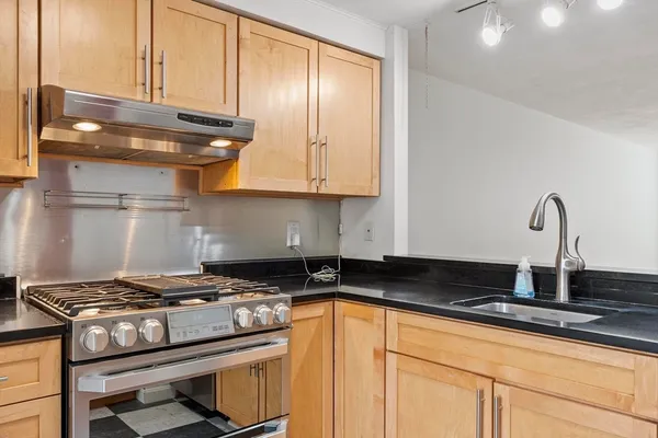 a kitchen with granite countertop a stove and a sink